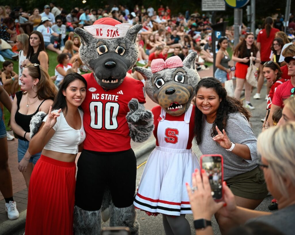 Students pose with Mr. and Mrs. Wuf at Packapalooza on Hillsborough street. Photo by Marc Hall.